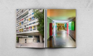 Modernist Estates Europe book open at a page with a photo of a high-rise block with brightly coloured panels on one page and a brightly decorated hallway on the other