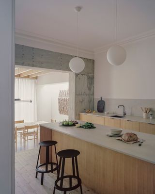 The Reform kitchen is in the original house, with the dining room seen through the new concrete structure