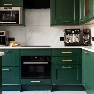 Forest green kitchen cabinets with white countertop