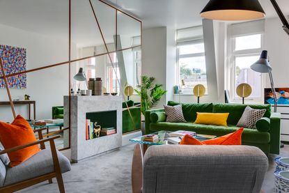 Small living with green sofa and modern furniture with mirror wall