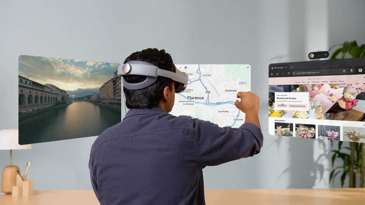 A man wearing a Samsung Galaxy XR interacting with floating windows using his hands