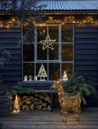 An outdoor space with Christmas-themed lighting including star and LED reindeer