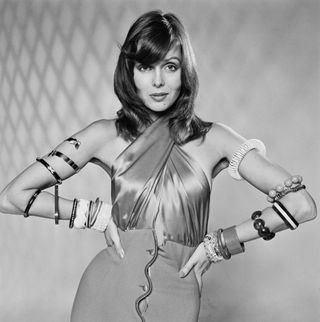 model wearing a halterneck dress and a variety of armbands and bracelets, UK, 27th November 1973.