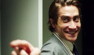 Nightcrawler Jake Gyllenhaal points and smiles at a co-worker