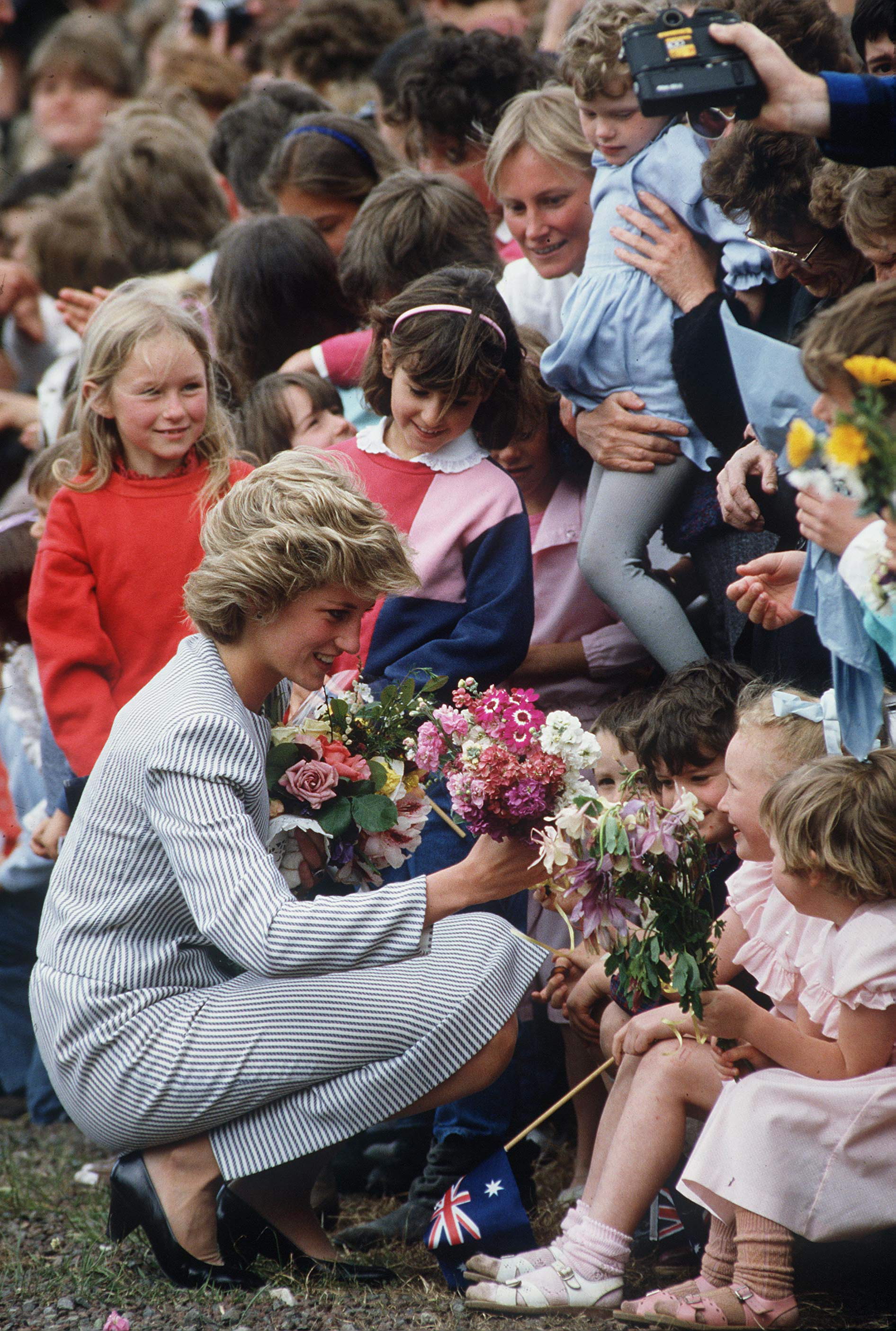 Princess Diana kneeling down talking to children in Australia in 1983