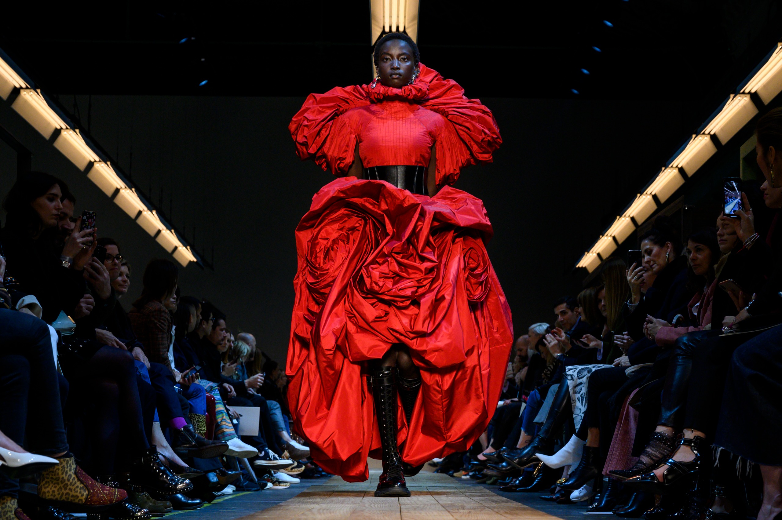 A model walks down the runway in an elaborate red dress