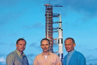 Armstrong, Collins and Aldrin (left to right) pose for news photographers with the Saturn V behind them on May 20.