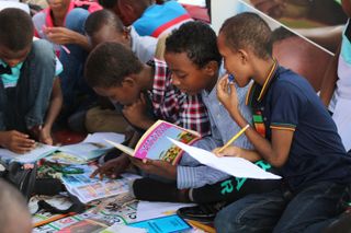 A group of students work together looking over each other's notes