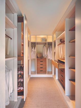 walk in closet with white and wood storage sections, open drawers, shelving and hanging, pull out shoe storage, lighting.