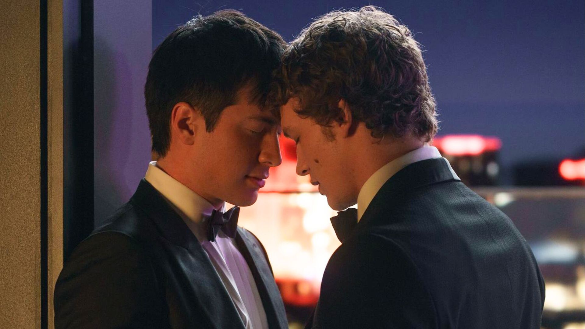 Two guys lean in to kiss each other