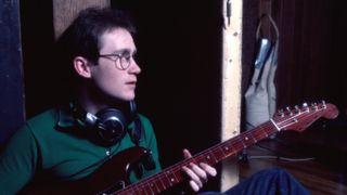 Marshall Crenshaw, headphones around his neck, as he plays guitar at the Record Plant Recording Studio, New York, New York, January 27, 1982. He was there to record his debut album, 'Marshall Crenshaw'.