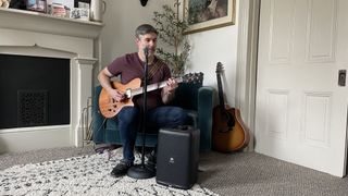 TechRadar freelance writer James Holland, using the JBL EOn One Compact with his guitar for an intimate gig 