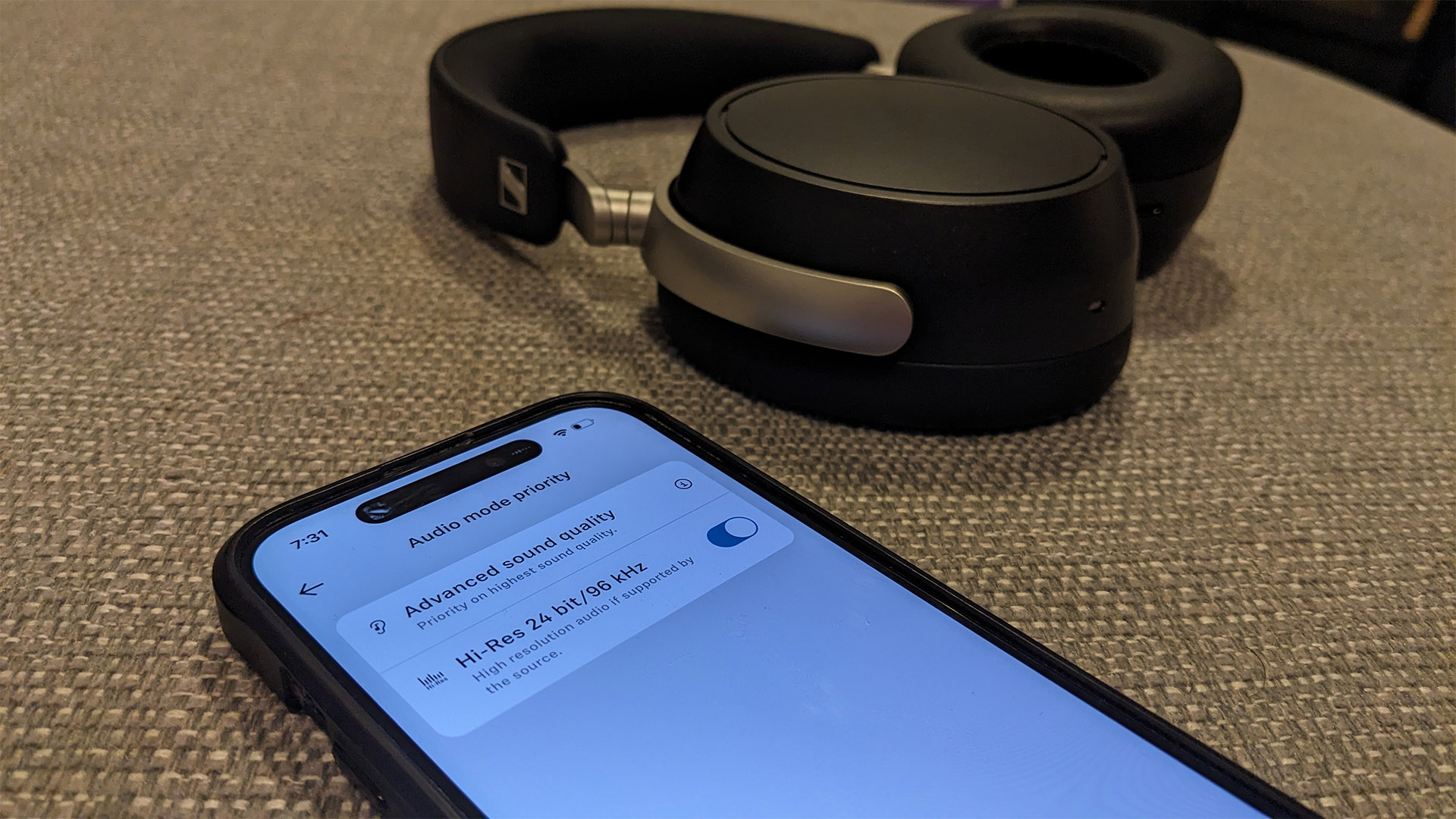 Sennheiser HDB 630 over-ear headphones on beige fabric next to iPhone