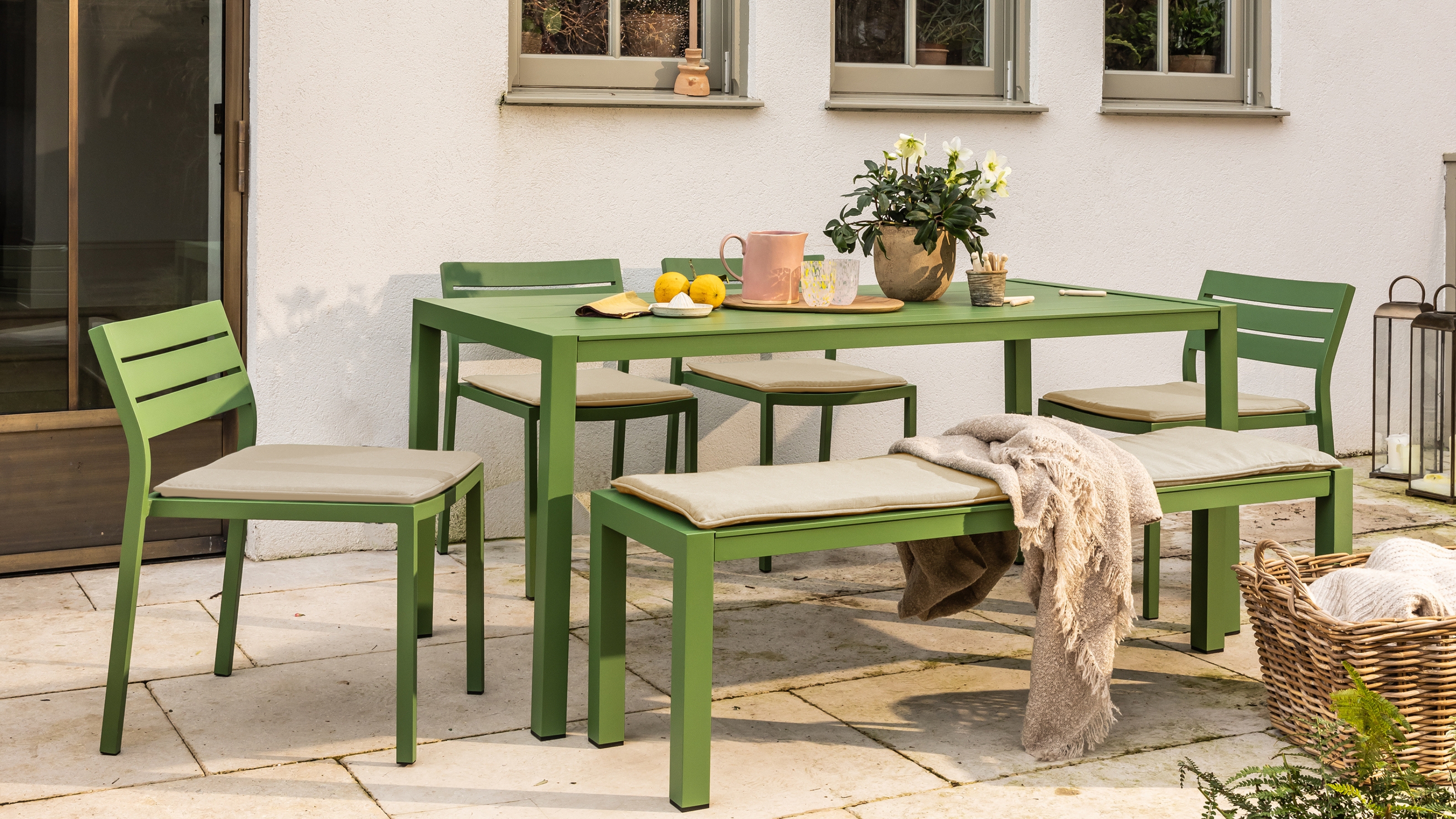a green garden table on a patio set for breakfast