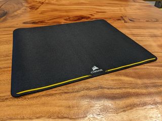 The Corsair MM200 mouse pad on a wooden table