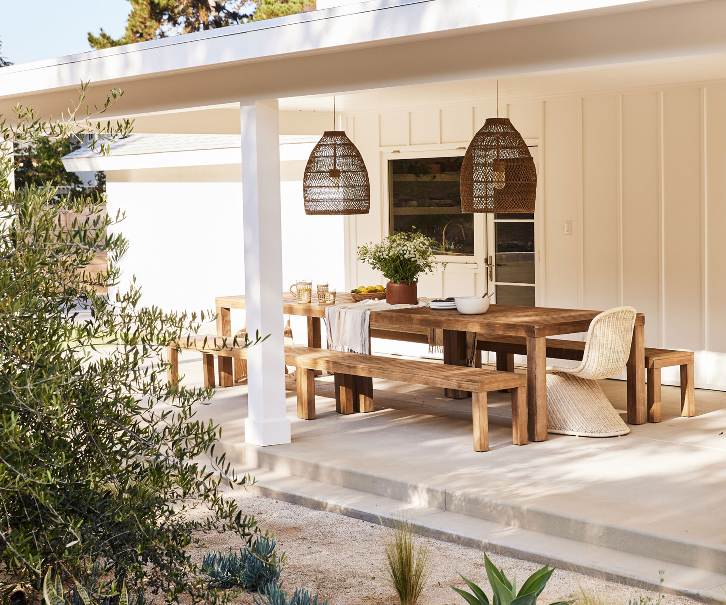 modern desert style outdoor dining area with pergola, gravel landscaping and furniture