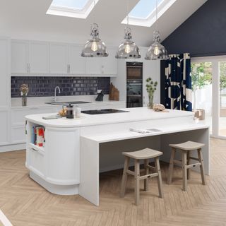 white kitchen with wooden herringbone flooring
