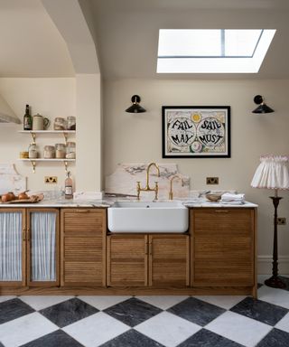 devol wooden kitchen cabinets with black and white checkerboard floor and a pink marble countertop and backsplash