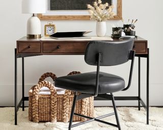 Dark wooden console table desk with black chair and basket