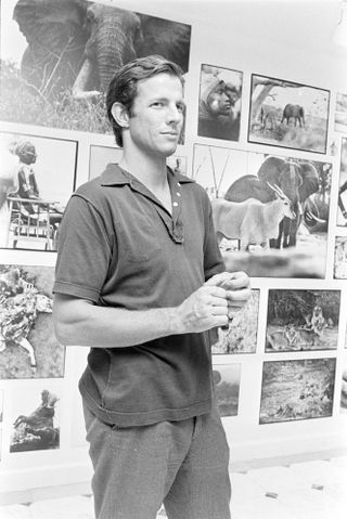 Man in polo shirt standing in front of photographs