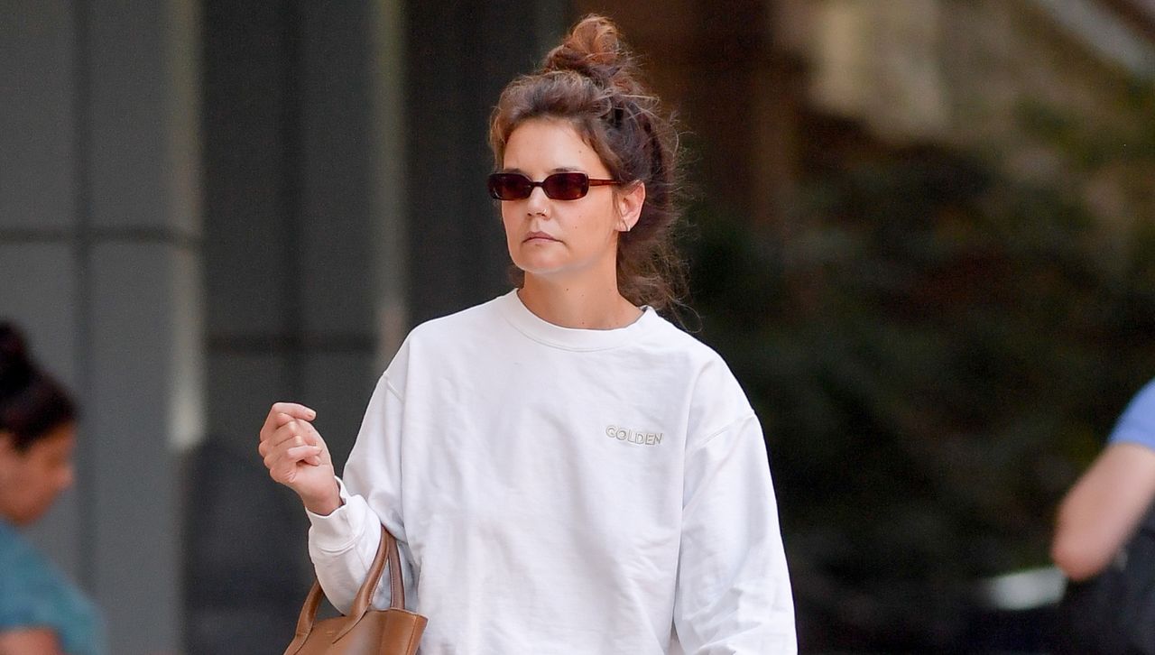 Katie Holmes wears a messy top bun with sunglasses and adidas sneakers in new york city