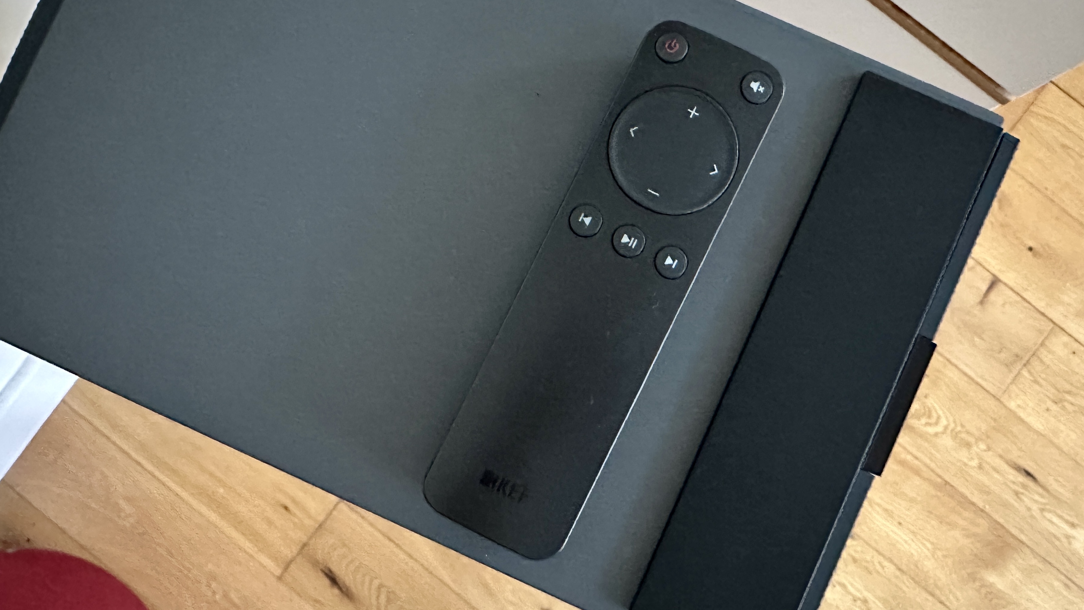 Top panel of the KEF Coda W active speaker system, with a remote control resting on top.