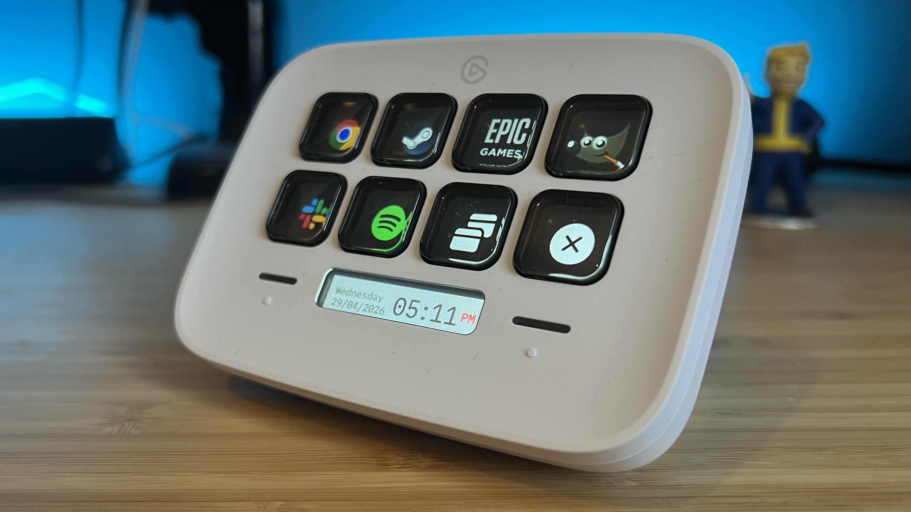 Stream Deck Neo in white on a wooden desk with blue backlighting