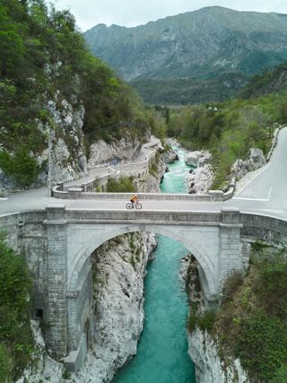 A cyclist rides across an old bridge in Slovenia