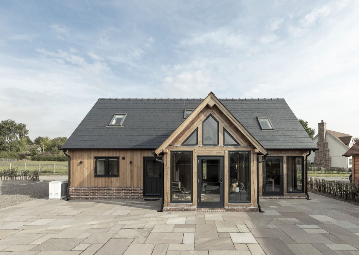 A partially glazed oak frame cottage with a paved exterior