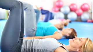 A row of women in pilates table-top position
