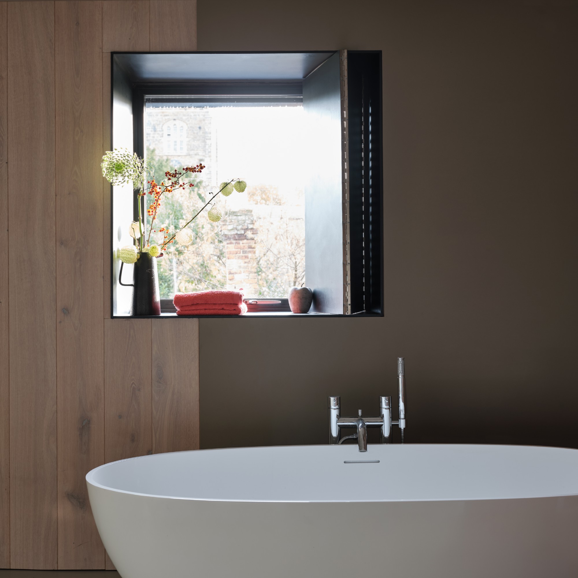A bathroom with an oval bathtub and the wall painted in Farrow &amp;amp; Ball's Mouse's Back with part of the wall panelled