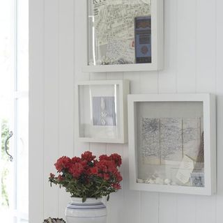 white wall with box frames and flower vase