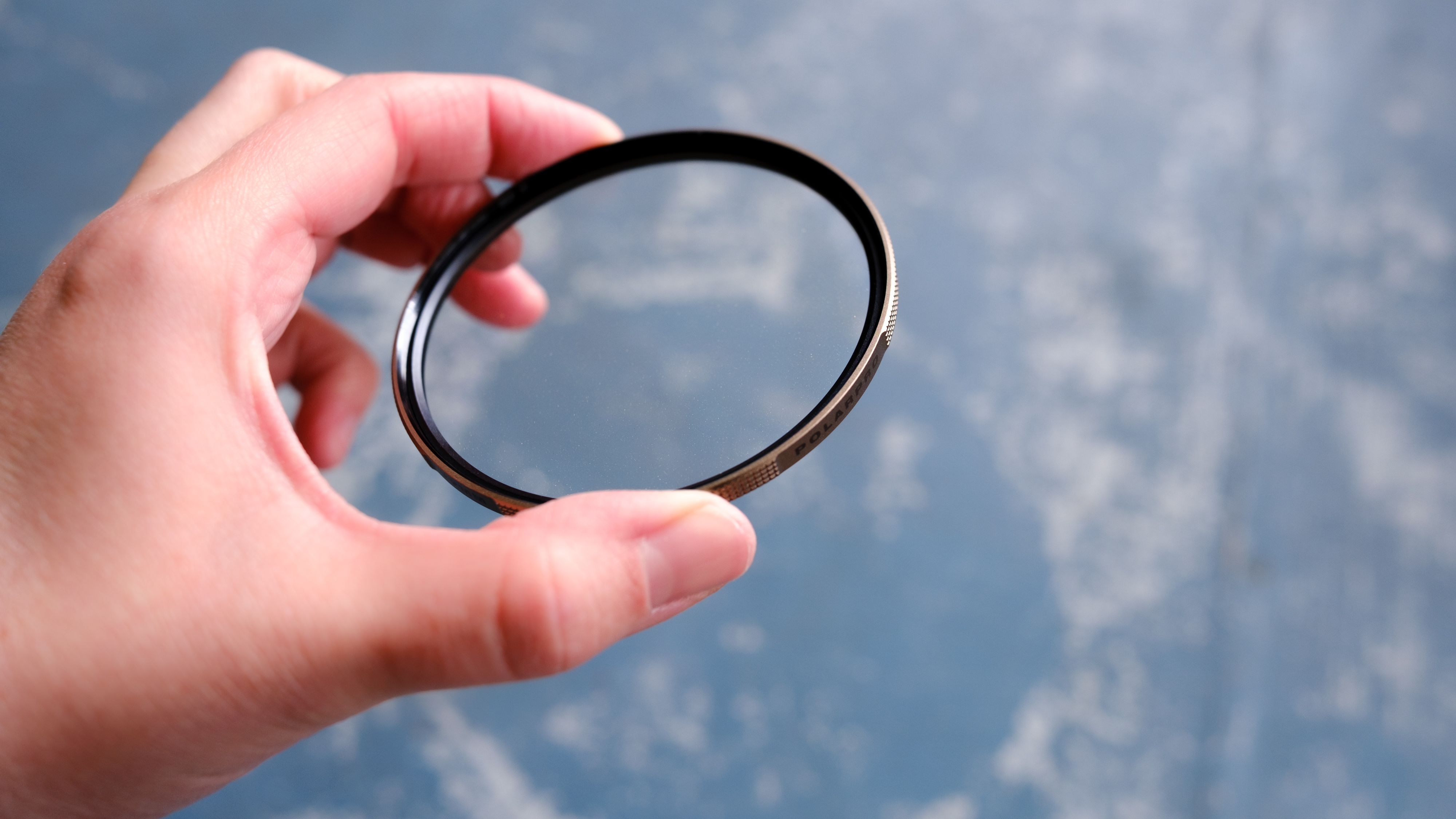The Polar Pro McKinnon 135 Gold Mist filter held in a person's hand