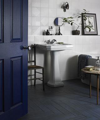 Navy blue bathroom scheme with dark blue door and floor tiles by Walls and Floors