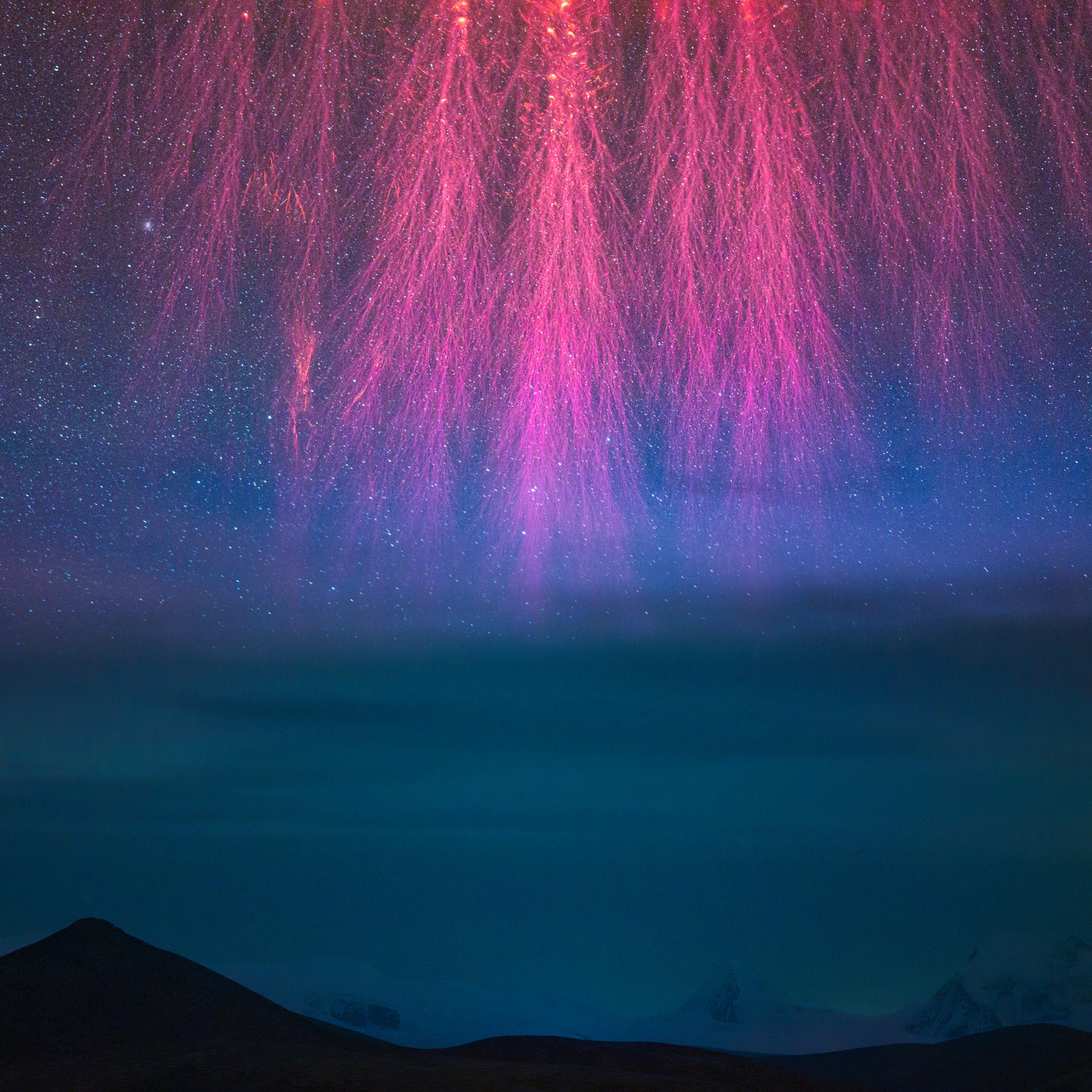 Red/pink spikes with numerous branches reach down from the top of the image like lightning strikes over dark mountains