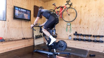 Image shows cyclist riding one of the best exercise bikes