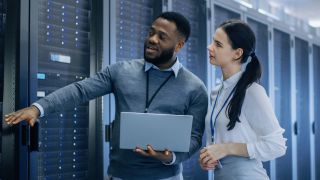 Man and woman looking at server racks