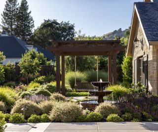 Rustic fountain, Mediterranean planting and modern wooden rope swing