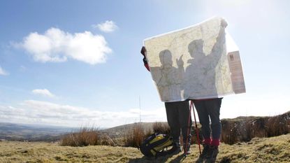 A pair of retirees read a map together on a sunny day.