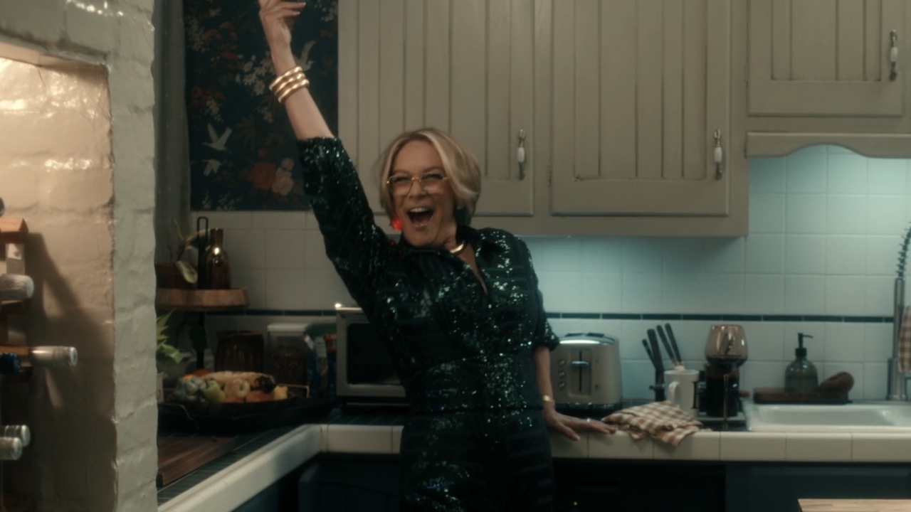 スカーペッタ エピソード 1 でライトアップ イヤリングでポーズをとるジェイミー リー カーティス。