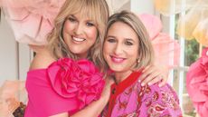 Sara Davies and Hannah Fernando wearing pink and smiling at the camera 
