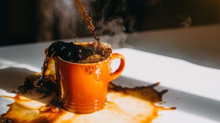 Coffee spilling as it&#039;s poured into cup