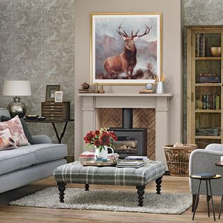 living room with stag artwork on wall and footstool with flower jug
