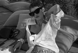 Black and white photo of a model wearing a J.Crew shirt and linen trousers.