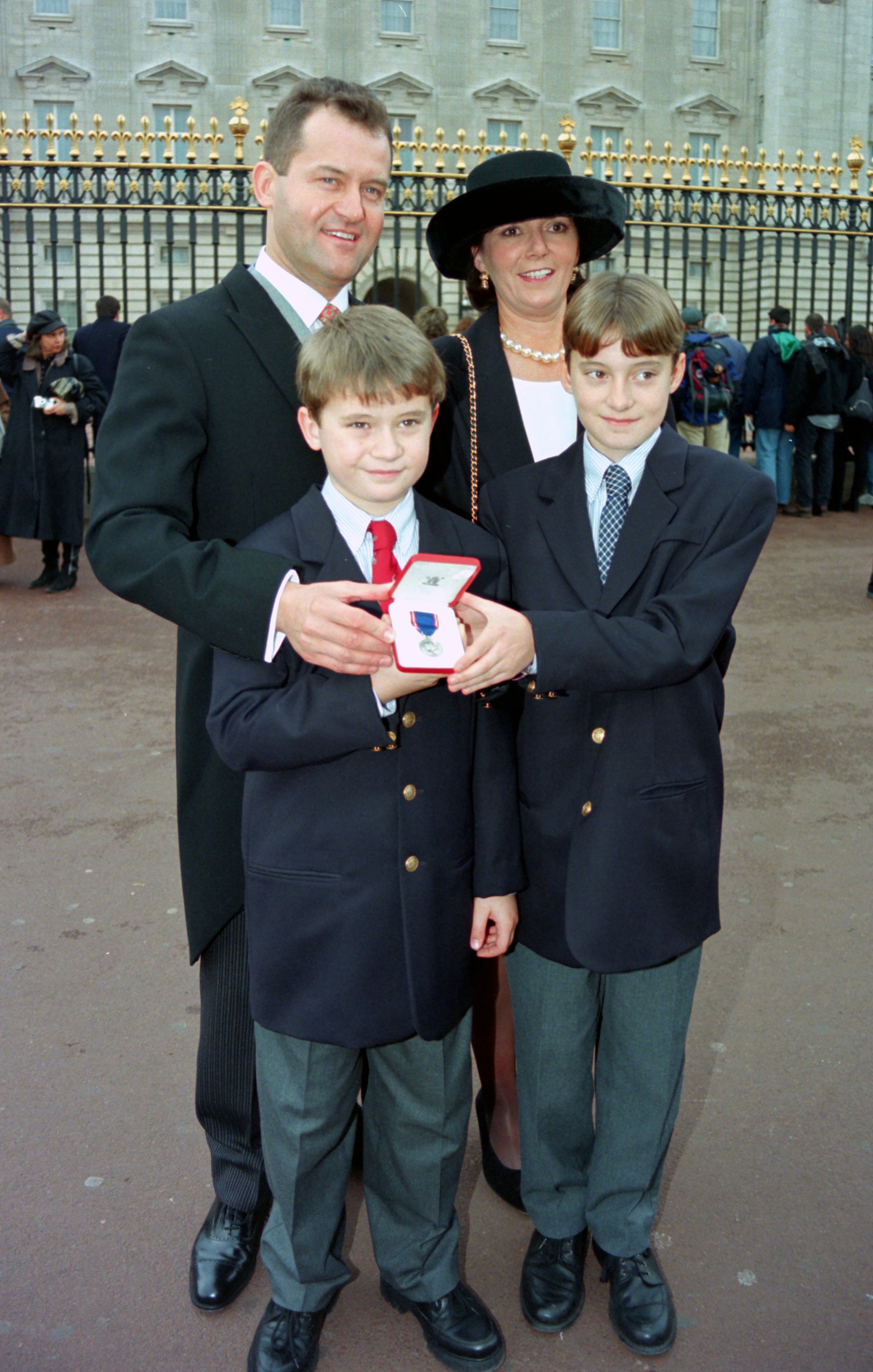 Paul Burrell and his ex-wife Maria pose with their sons in front of Buckingham Palace