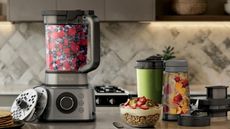 Ninja Foodi Power Blender Ultimate System on a kitchen counter filled with fresh berries. 