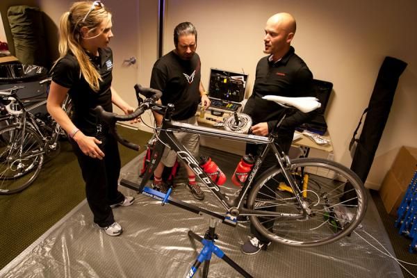 SRAM's Alex Wassmann, right, shows Alison Tetrick Starnes and Tim Brennan installation techniques of the SRAM-SRM crankset. Wassmann, liason to teams such as Radio Shack and Garmin-Cervelo, has emphasized SRAM's support to this team and Kristin Armstrong.
