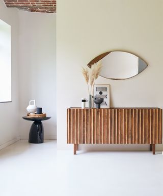 Milo sideboard with eye shaped mirror pampas grass and exposed brick ceiling