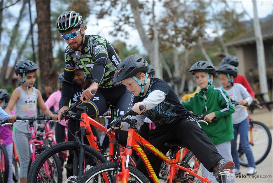 Peter Sagan rides along with a kid