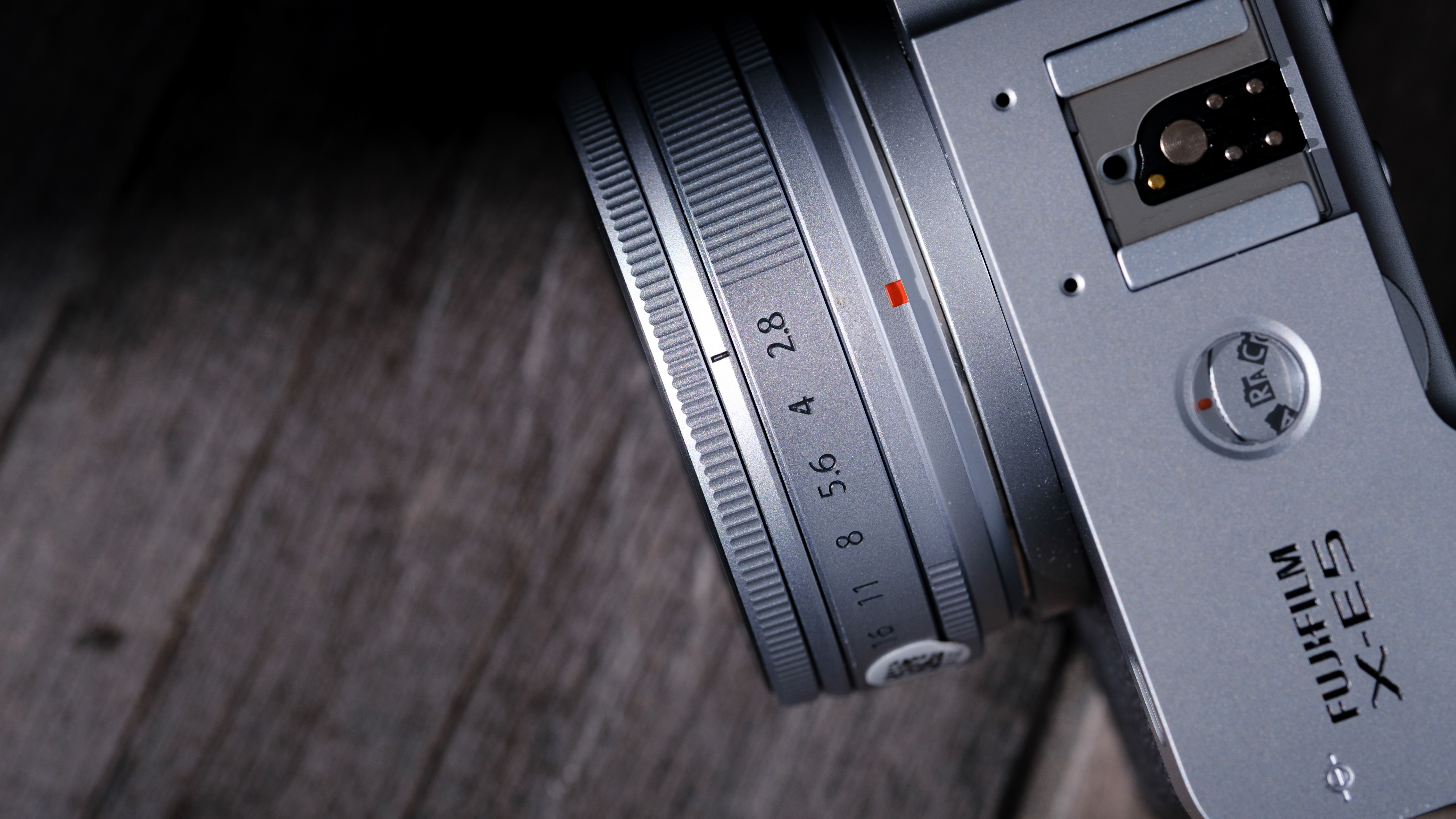 The Fujifilm XF 23mm f/2.8 R WR on a gray wood-like surface